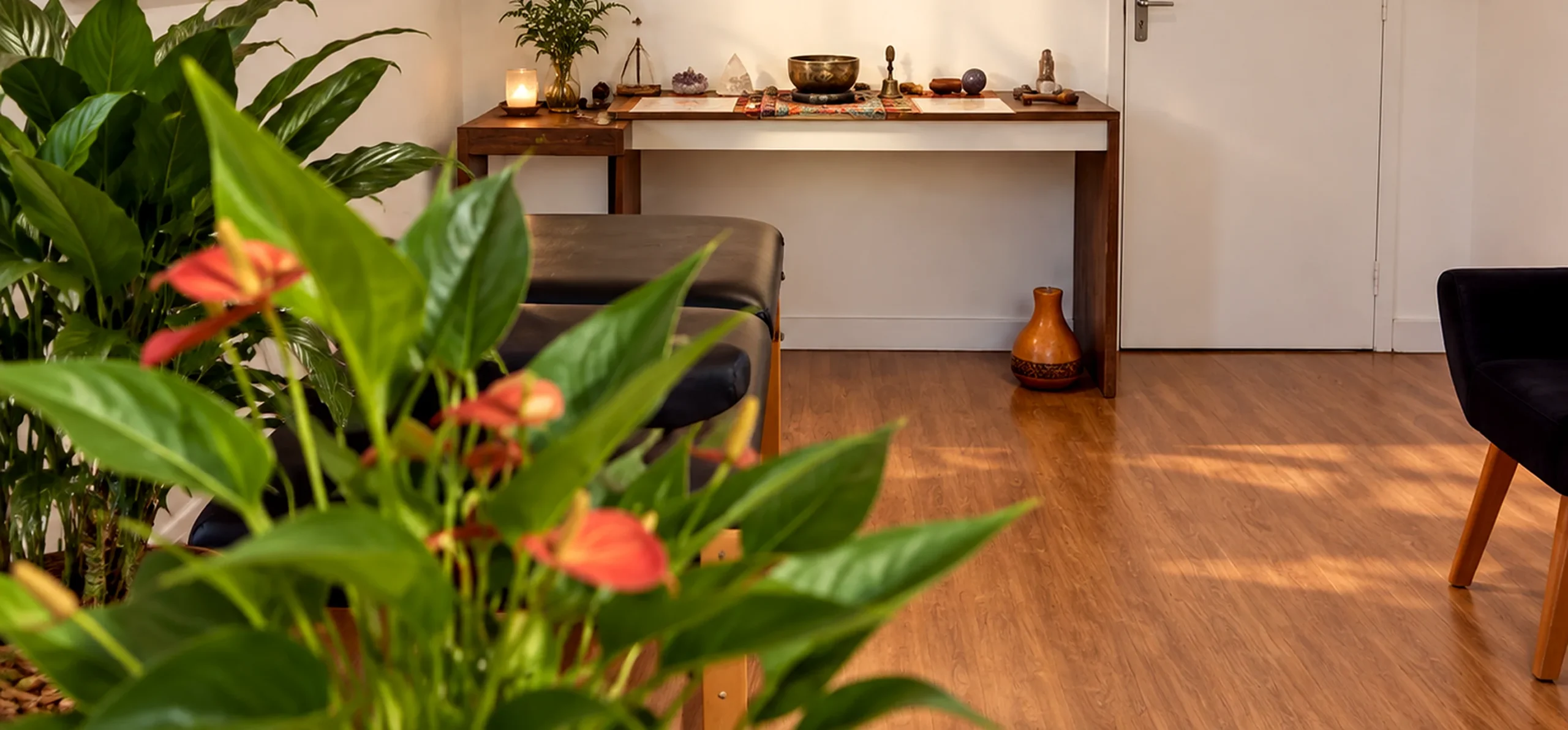 Sala de atendimento com mesa de objetos e piso de madeira.